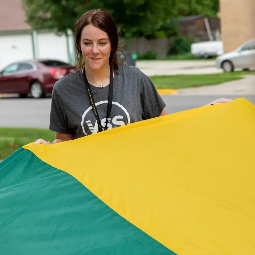 Smiling woman holding a yellow parachute