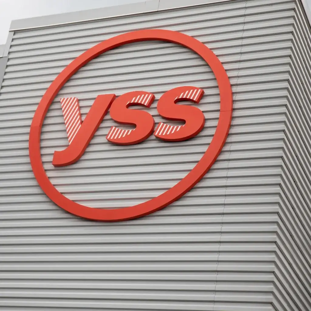 Orange YSS logo sign on the outside of a gray building.