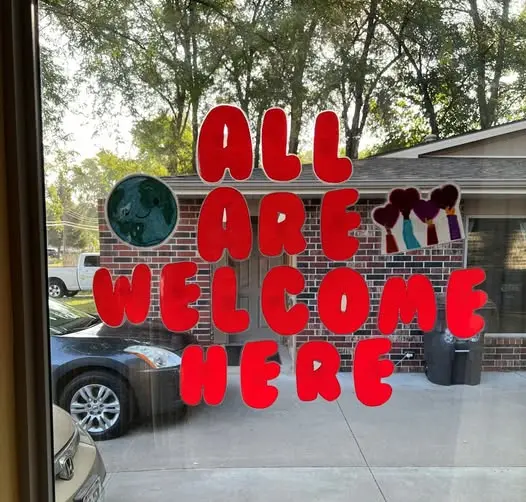 Window sign that says All Are Welcome Here.