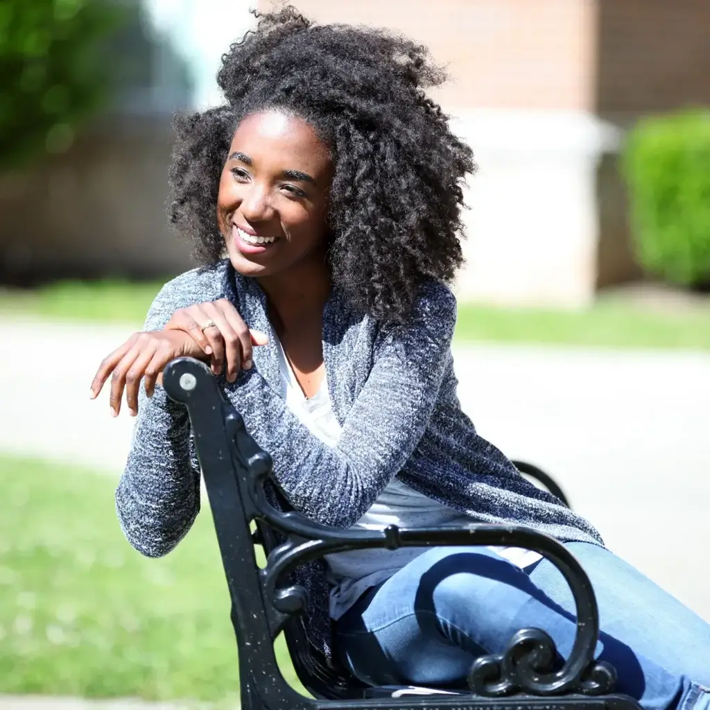 Smiling teen girl sitting on a bench