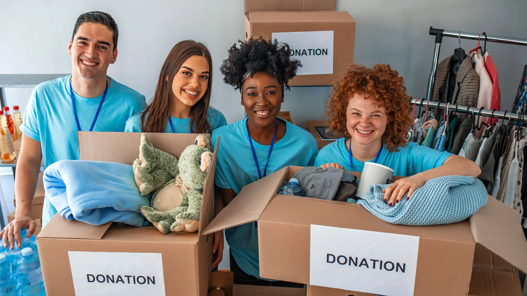 Four volunteers smiling with donated goods