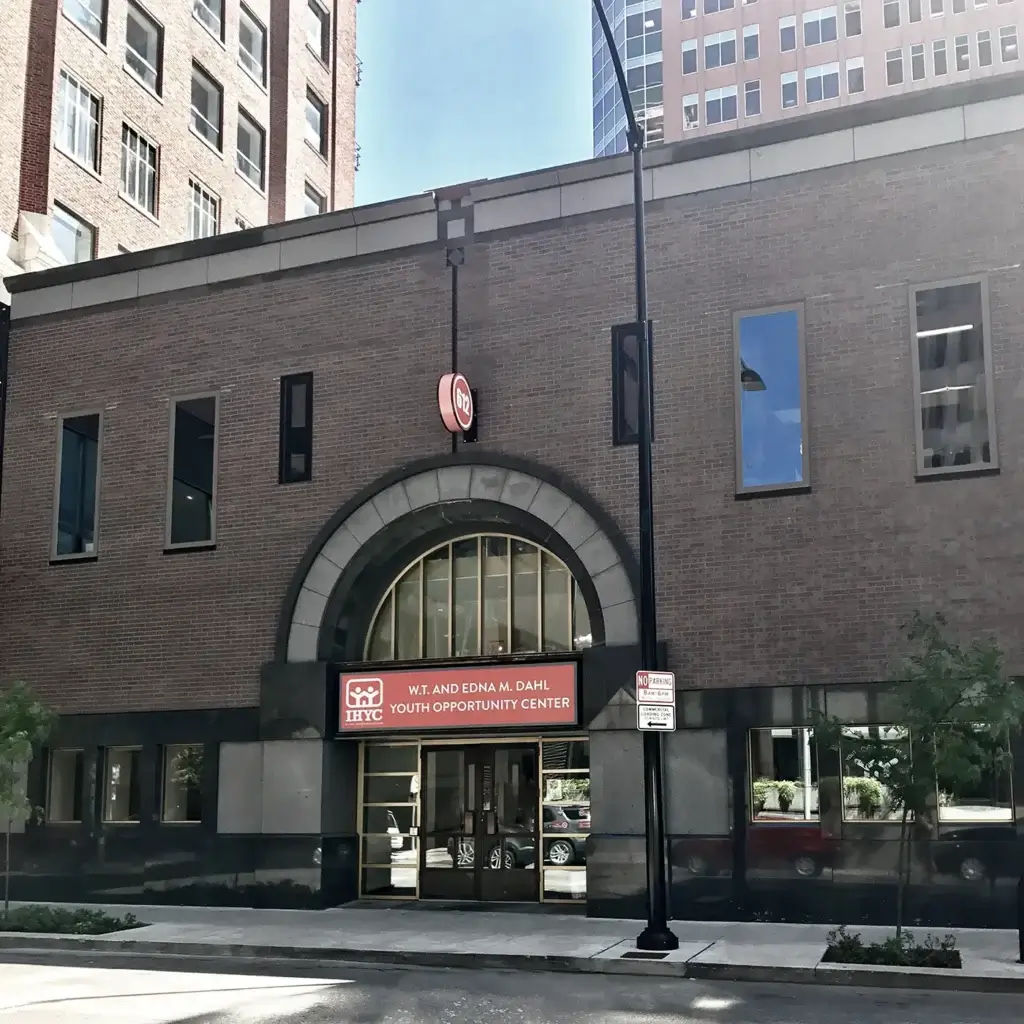 Exterior of a brick building with an arched entryway. The orange sign reads "W.T. and Edna M. Dahl Youth Opportunity Center"